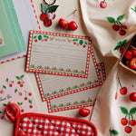 Tarjetas Cherry Farm sobre un paño con cerezas